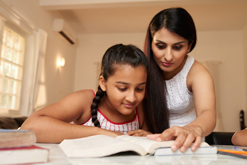 Mother helping her daughter study.